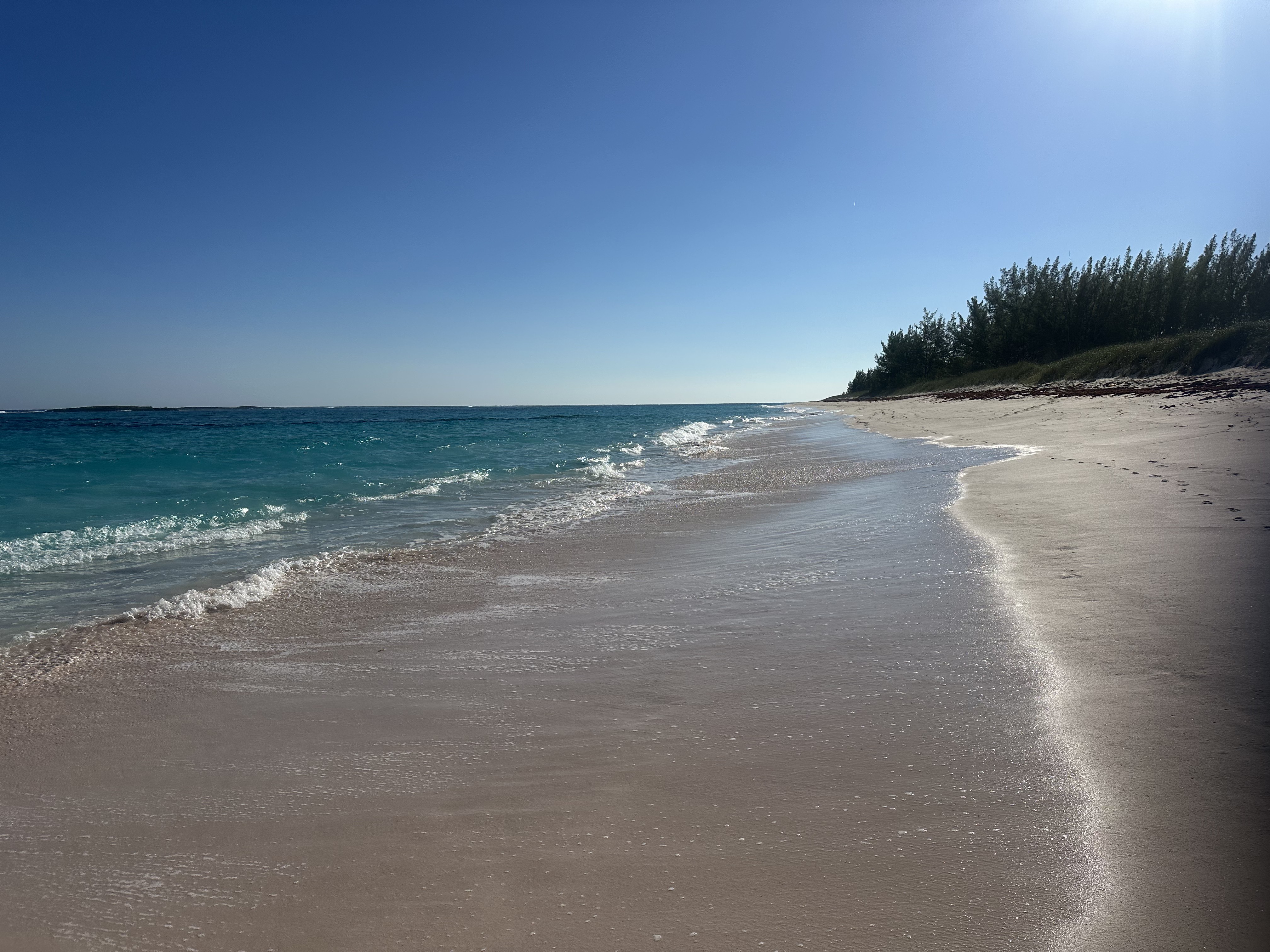 Turquoise waves washing onto a quiet white-sand beach